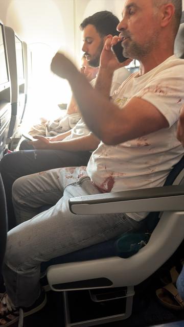 (260930) -- TEL AVIV, Sept. 30, 2026 (Xinhua) -- This photo released by an Israeli media agency shows a passenger with bloodstains on his clothes aboard a Flydubai commercial flight from Dubai to Tel Aviv, on Sept. 30, 2026. Israeli security agencies were investigating an incident aboard a Flydubai flight from Dubai to Tel Aviv after the aircraft transmitted an emergency signal and descended sharply before diverting to Saudi Arabia on Wednesday. (Xinhua)