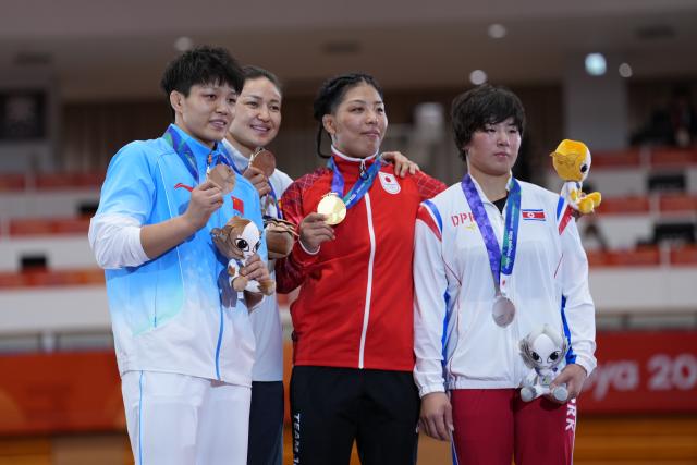 (260930) -- NAGOYA, Sept. 30, 2026 (Xinhua) -- Gold medalist Ishii Ami (2nd R) of Japan, silver medalist Pak Sol Gum (1st R) of the Democratic People's Republic of Korea (DPRK) and bronze medalists China's Long Jia (1st L) and Kyrgyzstan's Meerim Zhumanazarova pose during the awarding ceremony for the Women's 68kg of Wrestling at the 20th Asian Games Aichi-Nagoya 2026 in Nagoya, Japan, Sept. 30, 2026. (Xinhua/Li Bo)