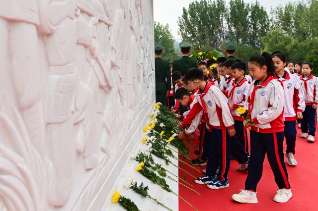 (260930) -- BEIJING, Sept. 30, 2026 (Xinhua) -- Students present flowers to a monument at a martyrs' cemetery in Qingzhou City, east China's Shandong Province, Sept. 30, 2026. Commemorative events were held across China to mark Martyrs' Day in recent days. Observed on Sept. 30, one day before National Day, the day commemorates those who gave their lives for national independence and prosperity. (Photo by Wang Jilin/Xinhua)