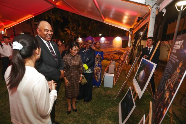 (260930) -- DAR ES SALAAM, Sept. 30, 2026 (Xinhua) -- Tanzanian Minister for Foreign Affairs and East African Cooperation Mahmoud Thabit Kombo (2nd, L) and Chinese Ambassador to Tanzania Chen Mingjian (3rd, L) view a photo exhibition during a reception hosted by the Chinese Embassy to mark the 77th anniversary of the founding of the People's Republic of China, in Dar es Salaam, Tanzania, Sept. 29, 2026. TO GO WITH "Tanzanian FM praises China ties, vows closer cooperation" (Xinhua/Emmanuel Herman)