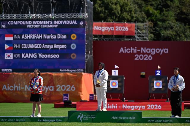(261001) -- OKAZAKI, Oct. 1, 2026 (Xinhua) -- Gold medalist Nurisa Dian Ashrifah (C) of Indonesia, silver medalist Amaya Amparo Cojuangco (L) of the Philippines, bronze medalist Kang Yeonseo of South Korea react during the victory ceremony for the compound women's individual of archery at the 20th Asian Games Aichi-Nagoya 2026 in Okazaki of Aichi Prefecture, Japan, Oct. 1, 2026. (Xinhua/Yu Yang)