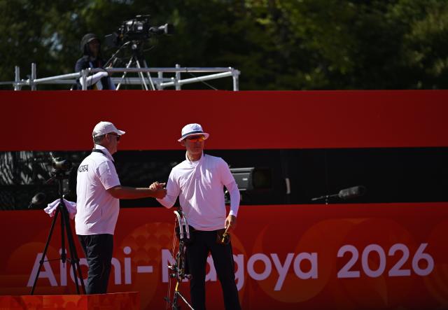 (261001) -- OKAZAKI, Oct. 1, 2026 (Xinhua) -- Kim Jongho (R) of South Korea shakes hands with his coach Sergio Pagni during the compound men's individual quarterfinals of archery against Liao Jiahao of China at the 20th Asian Games Aichi-Nagoya 2026 in Okazaki of Aichi Prefecture, Japan, Oct. 1, 2026. (Xinhua/Yu Yang)