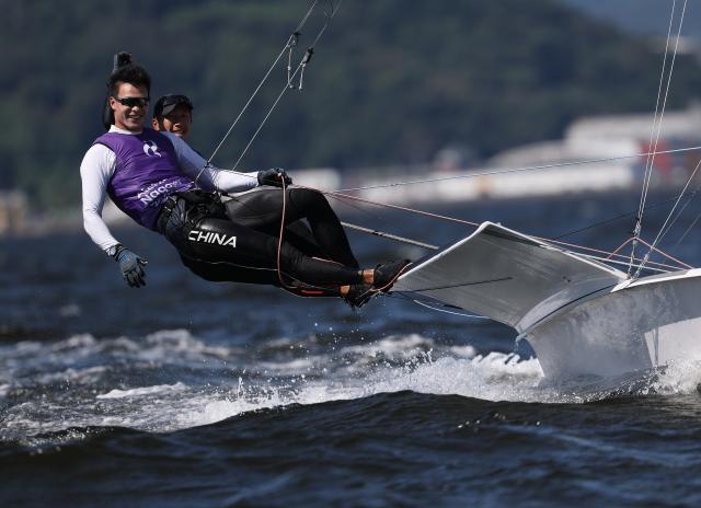 (261001) -- GAMAGORI, Oct. 1, 2026 (Xinhua) -- Liu Tian (front) and Wen Zaiding of China celebrate after the Men's Skiff Opening Series Race of Sailing at the 20th Asian Games Aichi-Nagoya 2026 in Gamagori of Aichi Prefecture, Japan, Oct. 1, 2026. (Xinhua/Deng Hua)