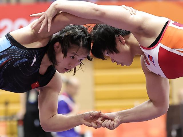 (261001) -- NAGOYA, Oct. 1, 2026 (Xinhua) -- Zhang Qi (L) of China competes with Kim Ok Ju of the Democratic People's Republic of Korea (DPRK) during their Women's 62kg Semifinal bout of Wrestling at the 20th Asian Games Aichi-Nagoya 2026 in Nagoya, Japan, Oct. 1, 2026 (Xinhua/Long Lei)