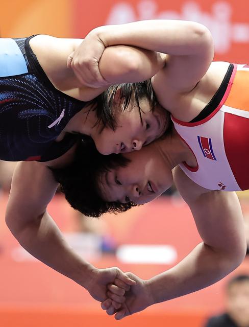 (261001) -- NAGOYA, Oct. 1, 2026 (Xinhua) -- Zhang Qi (L) of China competes with Kim Ok Ju of the Democratic People's Republic of Korea (DPRK) during their Women's 62kg Semifinal bout of Wrestling at the 20th Asian Games Aichi-Nagoya 2026 in Nagoya, Japan, Oct. 1, 2026 (Xinhua/Long Lei)