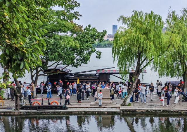 (261001) -- BEIJING, Oct. 1, 2026 (Xinhua) -- Tourists visit the Nanhu Lake scenic area in Jiaxing, east China's Zhejiang Province, Oct. 1, 2026. People celebrated the 77th anniversary of the founding of the People's Republic of China in various ways on Thursday. (Xinhua/Xu Yu)