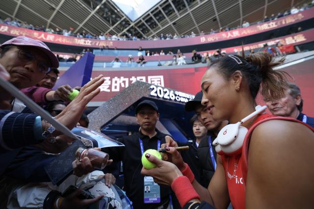 (261001) -- BEIJING, Oct. 1, 2026 (Xinhua) -- Zheng Qinwen signs autographs after the women's singles first round match between Zheng Qinwen of China and Shi Han of China at 2026 China Open tennis tournament in Beijing, China, Oct. 1, 2026. (Xinhua/Bai Xuefei)