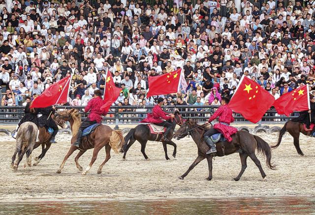 (261001) -- BEIJING, Oct. 1, 2026 (Xinhua) -- A drone photo taken on Oct. 1, 2026 shows people watching an equestrian performance at a tourism resort in Nantong, east China's Jiangsu Province. People celebrated the 77th anniversary of the founding of the People's Republic of China in various ways on Thursday. (Photo by Xu Congjun/Xinhua)