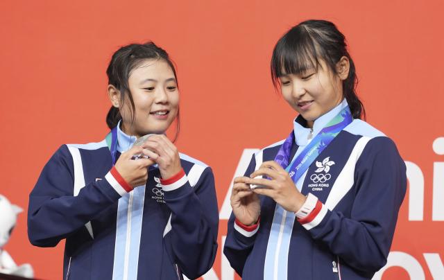 (260930) -- IZU, Oct.1, 2026 (Xinhua) -- Silver medalists Lee Sze Wing (R)/Leung Wing Yee of Hong Kong of China react during the awarding ceremony for the women's Madison of cycling track at the 20th Asian Games Aichi-Nagoya 2026 in Izu of Shizuoka Prefecture, Japan, Oct. 1, 2026. (Xinhua/Zhou Mi)