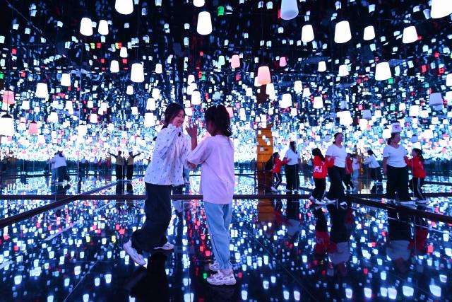(261001) -- BEIJING, Oct. 1, 2026 (Xinhua) -- People visit a light installation in Tengzhou City, east China's Shandong Province, Oct. 1, 2026. People across China stepped out to fully enjoy their leisure time during the National Day holiday. (Photo by Li Zhijun/Xinhua)