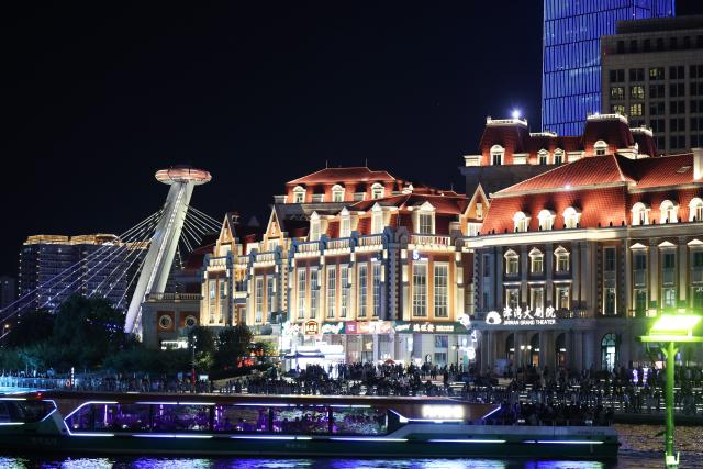 (261001) -- TIANJIN, Oct. 1, 2026 (Xinhua) -- Tourists enjoy themselves during a light show along the Haihe River in north China's Tianjin, Oct. 1, 2026. People across China stepped out to fully enjoy their leisure time during the National Day holiday. (Xinhua/Li Ran)