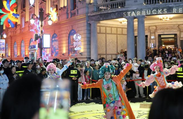 (261001) -- TIANJIN, Oct. 1, 2026 (Xinhua) -- Tourists watch a performance in north China's Tianjin, Oct. 1, 2026. People across China stepped out to fully enjoy their leisure time during the National Day holiday. (Xinhua/Li Ran)