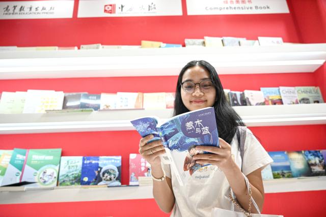 (261001) -- JAKARTA, Oct. 1, 2026 (Xinhua) -- Elvina, a Jakarta university student, reads a Mandarin-language book during the Indonesia International Book Fair 2026 in Jakarta, Indonesia, Sept. 30, 2026. TO GO WITH "Asia-Pacific Community: China-Indonesia book ties grow as Mandarin books find more readers" (Xinhua/Agung Kuncahya B.)