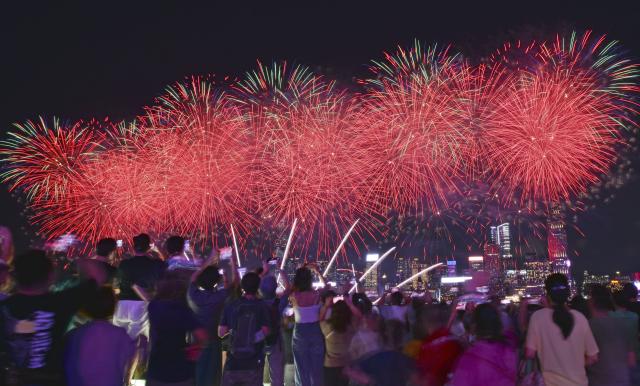 (261001) -- HONG KONG, Oct. 1, 2026 (Xinhua) -- Tourists watch the firework show celebrating the 77th anniversary of the founding of the People's Republic of China in Hong Kong, south China, Oct. 1, 2026. People across China stepped out to fully enjoy their leisure time during the National Day holiday. (Xinhua/Chen Duo)