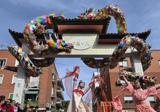 (261001) -- MADRID, Oct. 1, 2026 (Xinhua) -- People dance during the unveiling ceremony of the Chinese archway in Usera district of Madrid, Spain, Oct. 1, 2026. A Chinese archway featuring two dragons and Madrid's emblematic bear was unveiled Thursday in the Usera district of the Spanish capital, celebrating the neighborhood's cultural diversity and the ties with its Chinese community. (Xinhua/Cheng Min)