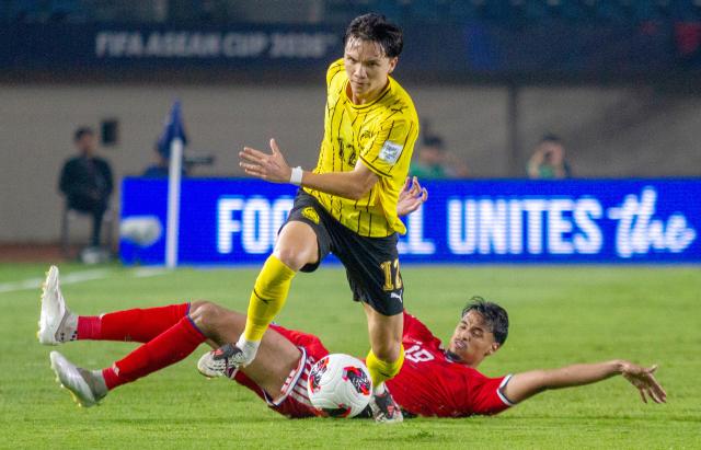 (261002) -- BANDUNG, Oct. 2, 2026 (Xinhua) -- Stuart Wilkin (top) of Malaysia vies with Ikhsan Fandi of Singapore during the FIFA ASEAN Cup 2026 Division 1 Group A match between Malaysia and Singapore at Si Jalak Harupat Stadium, in Bandung, West Java, Indonesia, Oct. 1, 2026. (Photo by Septianjar Muharam/Xinhua)