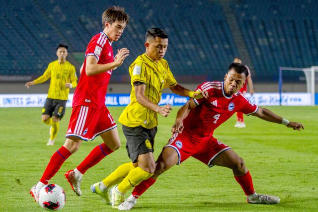 (261002) -- BANDUNG, Oct. 2, 2026 (Xinhua) -- Nur Adam Abdullah (R) of Singapore vies with Arif Aiman (2nd R) of Malaysia during the FIFA ASEAN Cup 2026 Division 1 Group A match between Malaysia and Singapore at Si Jalak Harupat Stadium, in Bandung, West Java, Indonesia, Oct. 1, 2026. (Photo by Septianjar Muharam/Xinhua)