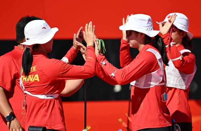 (261002) -- OKAZAKI, Oct. 2, 2026 (Xinhua) -- Huang Yuwei (2nd L), Yu Qi (1st R), Zhu Jingyi (2nd R) of team China celebrate with their coach after the recurve women's team bronze medal match of archery against team Indonesia at the 20th Asian Games Aichi-Nagoya 2026 in Okazaki of Aichi Prefecture, Japan, Oct. 2, 2026. (Xinhua/Yu Yang)