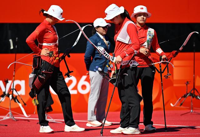 (261002) -- OKAZAKI, Oct. 2, 2026 (Xinhua) -- Huang Yuwei (front R), Yu Qi (front L), Zhu Jingyi (front C) of team China react during the recurve women's team bronze medal match of archery against team Indonesia at the 20th Asian Games Aichi-Nagoya 2026 in Okazaki of Aichi Prefecture, Japan, Oct. 2, 2026. (Xinhua/Yu Yang)