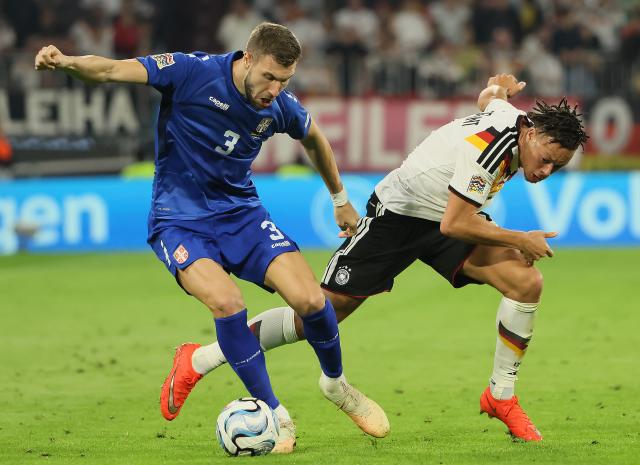 (261002) -- MUNICH, Oct. 2, 2026 (Xinhua) -- Derry Scherhant (R) of Germany vies with Strahinja Pavlovic of Serbia during the UEFA Nations League 2026/27 League A Group A2 match between Germany and Serbia in Munich, Germany, Oct. 1, 2026. (Photo by Philippe Ruiz/Xinhua)