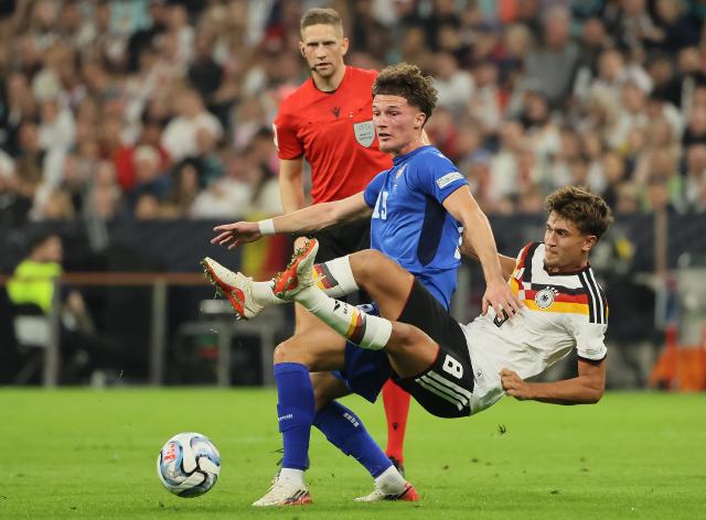 (261002) -- MUNICH, Oct. 2, 2026 (Xinhua) -- Tom Bischof (R) of Germany vies with Stefan Dzodic of Serbia during the UEFA Nations League 2026/27 League A Group A2 match between Germany and Serbia in Munich, Germany, Oct. 1, 2026. (Photo by Philippe Ruiz/Xinhua)