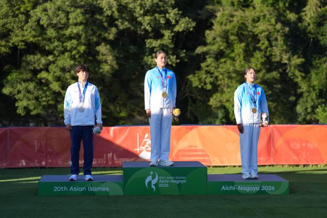 (261002) -- TOYOTA, Oct. 2, 2026 (Xinhua) -- Gold medalist Chen Lin (C) of China, silver medalist Chang Chu-han (L) of Chinese Taipei and bronze medalist Xu Linxi of China pose during the awarding ceremony for the women's kayak cross final of canoe slalom at the 20th Asian Games Aichi-Nagoya 2026 in Toyota of Aichi Prefecture, Japan, Oct. 2, 2026. (Xinhua/Zhang Haobo)