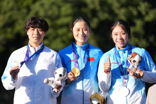 (261002) -- TOYOTA, Oct. 2, 2026 (Xinhua) -- Gold medalist Chen Lin (C) of China, silver medalist Chang Chu-han (L) of Chinese Taipei and bronze medalist Xu Linxi of China pose during the awarding ceremony for the women's kayak cross final of canoe slalom at the 20th Asian Games Aichi-Nagoya 2026 in Toyota of Aichi Prefecture, Japan, Oct. 2, 2026. (Xinhua/Zhang Haobo)
