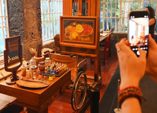 (261002) -- MEXICO CITY, Oct. 2, 2026 (Xinhua) -- A man takes photos of a wheelchair once used by Mexican painter Frida Kahlo at the Casa Azul Museum in Mexico City, Mexico, Oct. 1, 2026. Casa Azul Museum is the former residence of Mexican painter Frida Kahlo. (Xinhua/Zhang Lei)