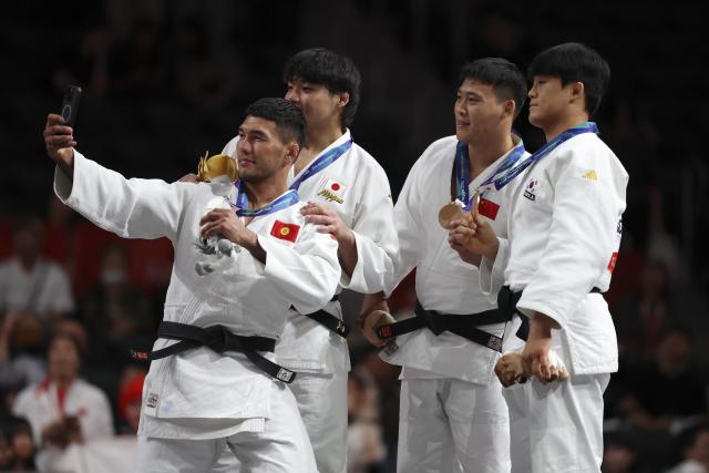 (261002) -- NAGOYA, Oct. 2, 2026 (Xinhua) -- Gold medalist Okada Riku (2nd L) of Japan, silver medalist Erlan Sherov (1st L) of Kyrgyzstan, and bronze medalists Han Qi (2nd R) of China and Kim Jonghoon of South Korea pose for a selfie during the awarding ceremony for the men -90kg of Judo at the 20th Asian Games Aichi-Nagoya 2026 in Nagoya, Japan, Oct. 2, 2026. (Xinhua/Yao Qilin)