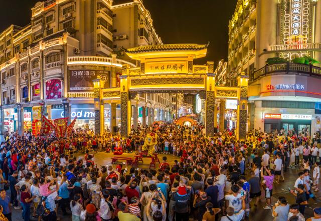 (261002) -- BEIJING, Oct. 2, 2026 (Xinhua) -- A drone photo taken on Oct. 1, 2026 shows people watching a performance near Qilou, or arcade buildings, in Wuzhou of south China's Guangxi Zhuang Autonomous Region. During the National Day holiday, various cultural and tourism events are held across the country to attract visitors. (Photo by He Huawen/Xinhua)