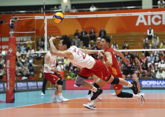(261002) -- OKAZAKI, Oct. 2, 2026 (Xinhua) -- Wang Bin (front) of China saves the ball during the men's volleyball semifinal match between China and Japan at the 20th Asian Games Aichi-Nagoya 2026 in Okazaki of Aichi Prefecture, Japan, Oct. 2, 2026. (Xinhua/Cheong Kam Ka)