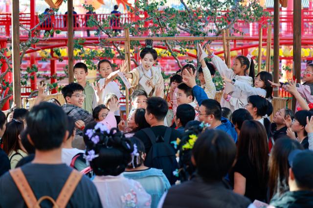 (261002) -- BEIJING, Oct. 2, 2026 (Xinhua) -- Staff members interact with tourists at a scenic area in Tangshan, north China's Hebei Province, Oct. 1, 2026. During the National Day holiday, people step outdoors to enjoy a vibrant holiday atmosphere. (Xinhua/Mu Yu)