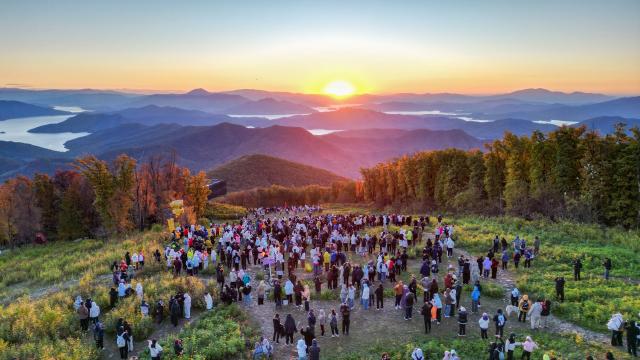 (261002) -- BEIJING, Oct. 2, 2026 (Xinhua) -- Tourists watch sunrise at the Lake Songhua Resort in Jilin City, northeast China's Jilin Province, Oct. 2, 2026. During the National Day holiday, people step outdoors to enjoy a vibrant holiday atmosphere. (Xinhua/Yan Linyun)