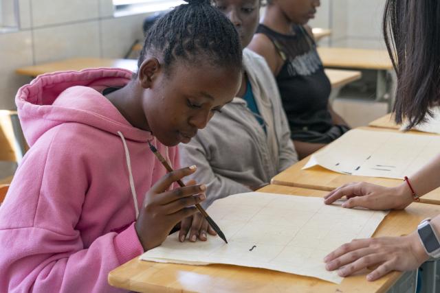 (261002) -- NAIROBI, Oct. 2, 2026 (Xinhua) -- Local students attend a calligraphy class at the Confucius Institute of Kenyatta University in Nairobi, Kenya, Oct. 1, 2026. The Confucius Institute at Kenyatta University, located in Nairobi, Kenya, is jointly established by Shandong Normal University and Kenyatta University, serving as a platform for local students to learn about China and experience Chinese culture. Besides formal classes, clubs of dancing, martial arts, calligraphy and painting, cuisine, and recitation are also popular among local students. (Xinhua/Xie Jianfei)