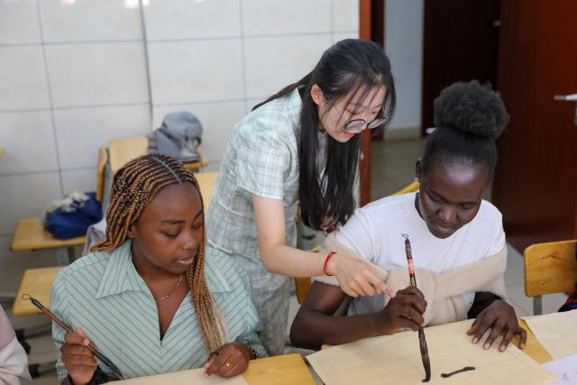 (261002) -- NAIROBI, Oct. 2, 2026 (Xinhua) -- Song Menglu (C), a Chinese teacher at the Confucius Institute of Kenyatta University, guides students in practicing basic strokes during a calligraphy class in Nairobi, Kenya, Oct. 1, 2026. The Confucius Institute at Kenyatta University, located in Nairobi, Kenya, is jointly established by Shandong Normal University and Kenyatta University, serving as a platform for local students to learn about China and experience Chinese culture. Besides formal classes, clubs of dancing, martial arts, calligraphy and painting, cuisine, and recitation are also popular among local students. (Xinhua/Liu Jiaqi)