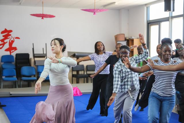 (261002) -- NAIROBI, Oct. 2, 2026 (Xinhua) -- Mu Yuying (1st L), a Chinese teacher at the Confucius Institute of Kenyatta University, teaches local students Chinese dance in Nairobi, Kenya, Oct. 1, 2026. The Confucius Institute at Kenyatta University, located in Nairobi, Kenya, is jointly established by Shandong Normal University and Kenyatta University, serving as a platform for local students to learn about China and experience Chinese culture. Besides formal classes, clubs of dancing, martial arts, calligraphy and painting, cuisine, and recitation are also popular among local students. (Xinhua/Liu Jiaqi)