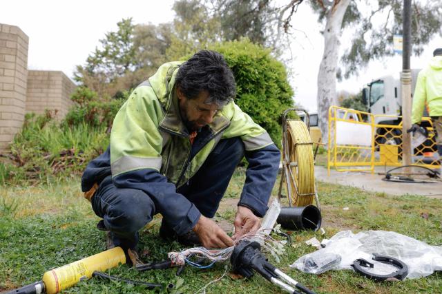 (261002) -- CANBERRA, Oct. 2, 2026 (Xinhua) -- A man works in the rain in Canberra, Australia, on Oct. 2, 2026. TO GO WITH "Job vacancies fall again in Australia" (Photo by Chu Chen/Xinhua)