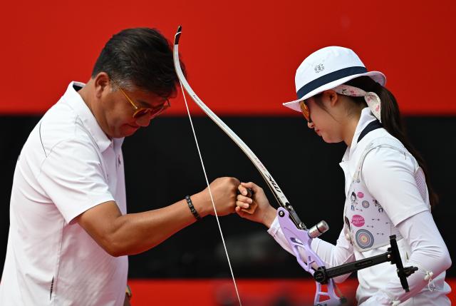 (261003) -- OKAZAKI, Oct. 3, 2026 (Xinhua) -- Oh Yejin (R) of South Korea and her coach fist bump during the Recurve Women's Individual Gold Medal Match of Archery against Kumkum Anil Mohod of India at the 20th Asian Games Aichi-Nagoya 2026 in Okazaki of Aichi Prefecture, Japan, Oct. 3, 2026. (Xinhua/Yu Yang)