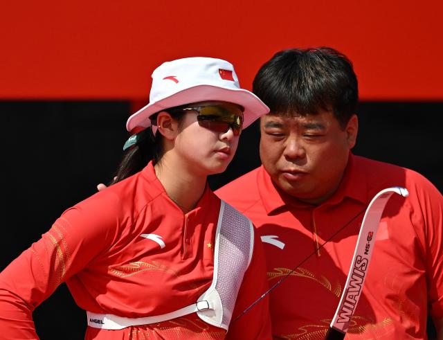 (261003) -- OKAZAKI, Oct. 3, 2026 (Xinhua) -- Zhu Jingyi (L) of China talks with her coach Kwon Yong-hak during the Recurve Women's Individual Bronze Medal Match of Archery against Huang Yuwei of China at the 20th Asian Games Aichi-Nagoya 2026 in Okazaki of Aichi Prefecture, Japan, Oct. 3, 2026. (Xinhua/Yu Yang)