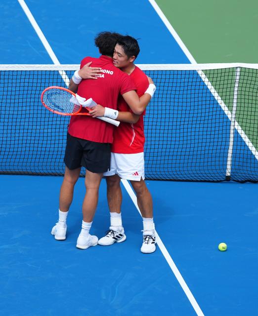 (261003) -- NAGOYA, Oct. 3, 2026 (Xinhua) -- Wong Coleman (L) hugs Wu Yibing after the Men's Singles Gold Medal Match of Tennis between Wu Yibing of China and Wong Coleman of Hong Kong, China at the 20th Asian Games Aichi-Nagoya 2026 in Nagoya, Japan, Oct. 3, 2026. (Xinhua/Chen Zeguo)