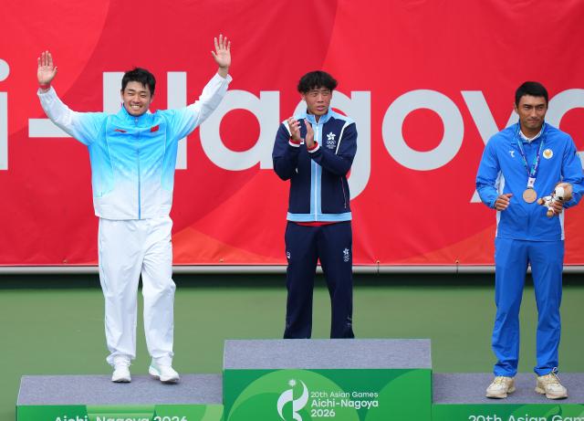(261003) -- NAGOYA, Oct. 3, 2026 (Xinhua) -- Silver medalist Wu Yibing (L) of China waves his hands as gold medalist Wong Coleman (C) of China's Hong Kong and bronze medalists Khumoyun Sultanov of Uzbekistan applaud during the victory ceremony for the Men's Singles of Tennis at the 20th Asian Games Aichi-Nagoya 2026 in Nagoya, Japan, Oct. 3, 2026. (Xinhua/Chen Zeguo)
