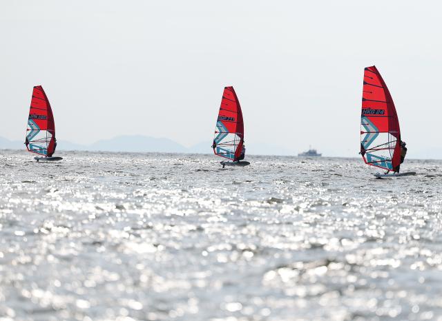 (261003) -- GAMAGORI, Oct. 3, 2026 (Xinhua) -- Cheung Tsz Yuet (R) of China's Hong Kong, Chew Angyal (C) of Singapore and Oshima Akari of Japan compete during the Girls' Windsurfing Opening Series Race of Sailing at the 20th Asian Games Aichi-Nagoya 2026 in Gamagori of Aichi Prefecture, Japan, Oct. 3, 2026. (Xinhua/Deng Hua)