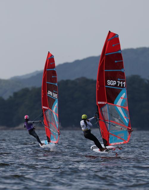 (261003) -- GAMAGORI, Oct. 3, 2026 (Xinhua) -- Chew Angyal (R) of Singapore and Oshima Akari of Japan compete during the Girls' Windsurfing Opening Series Race of Sailing at the 20th Asian Games Aichi-Nagoya 2026 in Gamagori of Aichi Prefecture, Japan, Oct. 3, 2026. (Xinhua/Deng Hua)