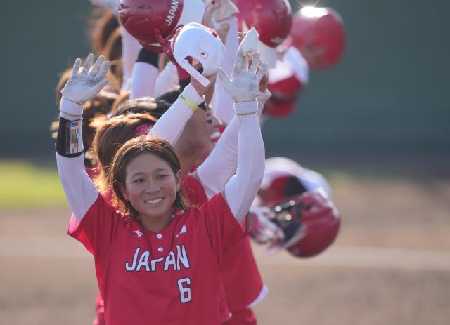 (261003) -- ANJO, Oct. 3, 2026 (Xinhua) -- Ishikawa Kyoko (front) of Japan celebrates winning the women's gold medal match of softball between China and Japan at the 20th Asian Games Aichi-Nagoya 2026 in Anjo of Aichi Prefecture, Japan, Oct. 3, 2026. (Xinhua/Luo Yuan)