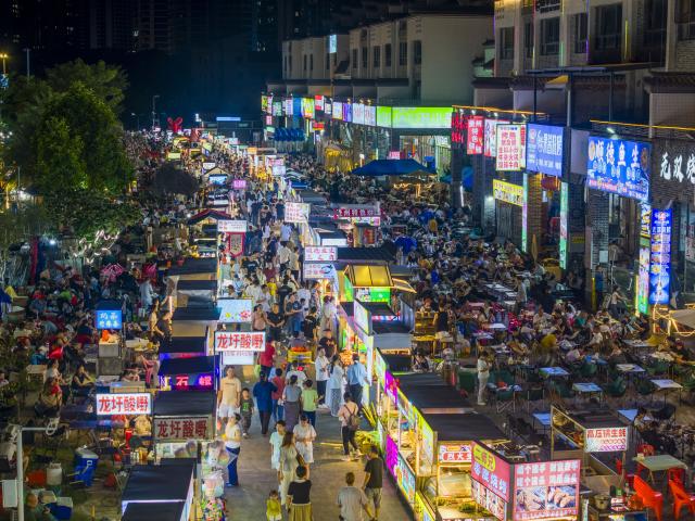 (261003) -- BEIJING, Oct. 3, 2026 (Xinhua) -- A drone photo shows people visiting a night market in Wuzhou, south China's Guangxi Zhuang Autonomous Region, Oct. 2, 2026.
  China's cultural and tourism market is thriving during this year's National Day holiday, with a wide range of options including scenic getaways, autumn outings, tourism with revolutionary topics, nighttime entertainment, and cultural tours featuring the country's intangible cultural heritage. (Photo by He Huawen/Xinhua)