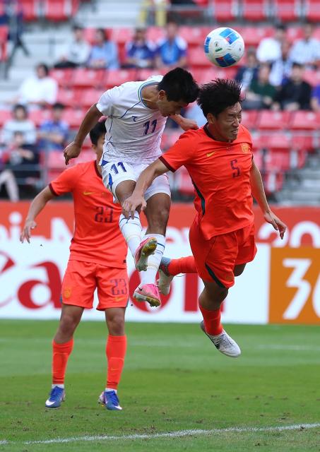 (261003) -- TOYOTA, Oct. 3, 2026 (Xinhua) -- Asilbek Jumaev (C) of Uzbekistan heads the ball during the men's 3rd place match of football between China and Uzbekistan at 20th Asian Games Aichi-Nagoya 2026 in Toyota of Aichi Prefecture, Japan, Oct. 3, 2026. (Xinhua/Jia Haocheng)