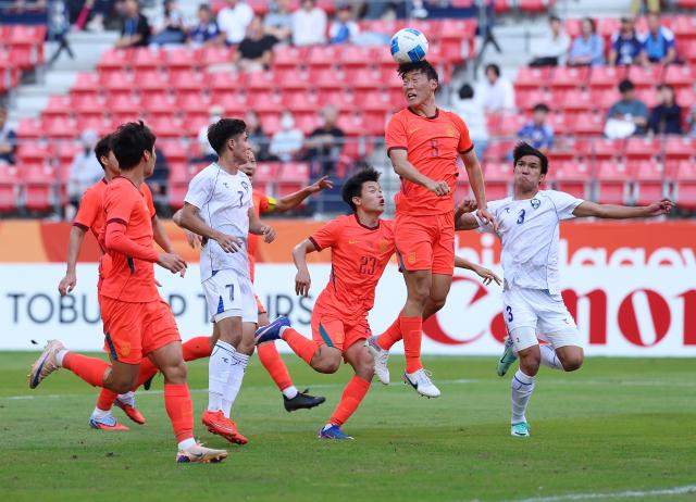 (261003) -- TOYOTA, Oct. 3, 2026 (Xinhua) -- Zhu Chenjie (2nd R) of China heads the ball during the men's 3rd place match of football between China and Uzbekistan at 20th Asian Games Aichi-Nagoya 2026 in Toyota of Aichi Prefecture, Japan, Oct. 3, 2026. (Xinhua/Jia Haocheng)