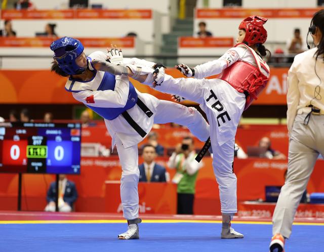 (261003) -- TOYOHASHI, Oct. 3, 2026 (Xinhua) -- Zhang Chuling (L) of China competes with Lin Wei-chun of Chinese Taipei during the women -57kg semifinal of taekwondo at the 20th Asian Games Aichi-Nagoya 2026 in Toyohashi of Aichi Prefecture, Japan, Oct. 3, 2026. (Xinhua/Wang Fei)