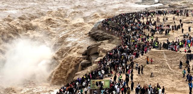 (261003) -- BEIJING, Oct. 3, 2026 (Xinhua) -- A drone photo shows tourists visiting the Yellow River's Hukou Waterfall scenic area in Jixian County, north China's Shanxi Province, Oct. 3, 2026.
  China's cultural and tourism market is thriving during this year's National Day holiday, with a wide range of options including scenic getaways, autumn outings, tourism with revolutionary topics, nighttime entertainment, and cultural tours featuring the country's intangible cultural heritage. (Photo by Lyu Guiming/Xinhua)