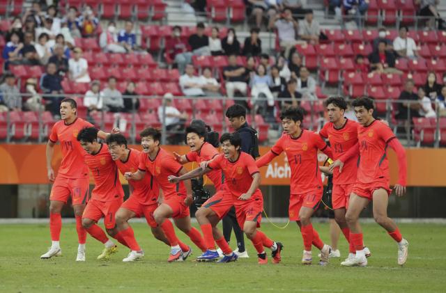 (261003) -- TOYOTA, Oct. 3, 2026 (Xinhua) -- Players of China celebrate after winning the men's 3rd place match of football between China and Uzbekistan at 20th Asian Games Aichi-Nagoya 2026 in Toyota of Aichi Prefecture, Japan, Oct. 3, 2026. (Xinhua/Lui Siu Wai)
